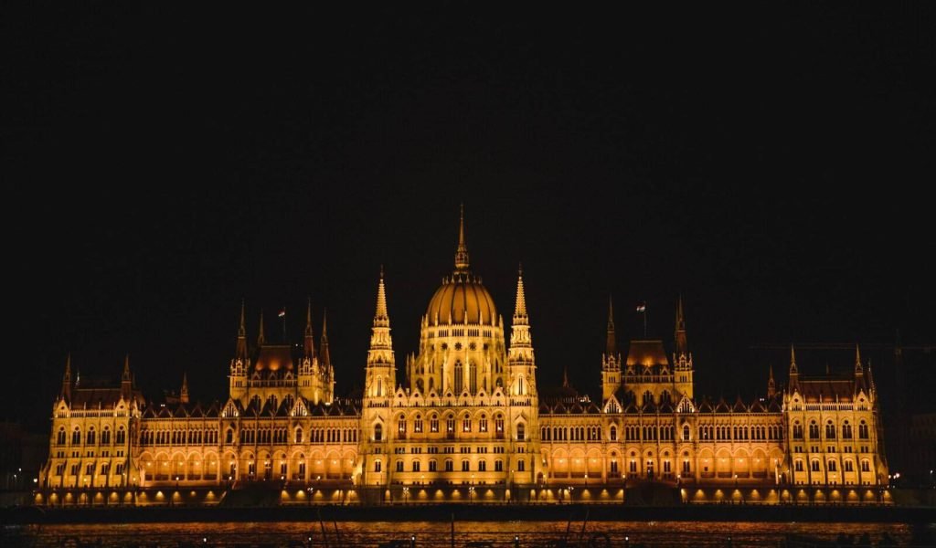 Travel Poland to Hungary: admire Budapest’s illuminated Parliament at night, a must-see landmark on a budget-friendly European journey.